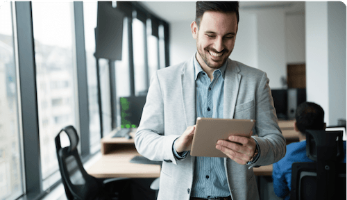 white male smiling in suit on ipad on video call with provider