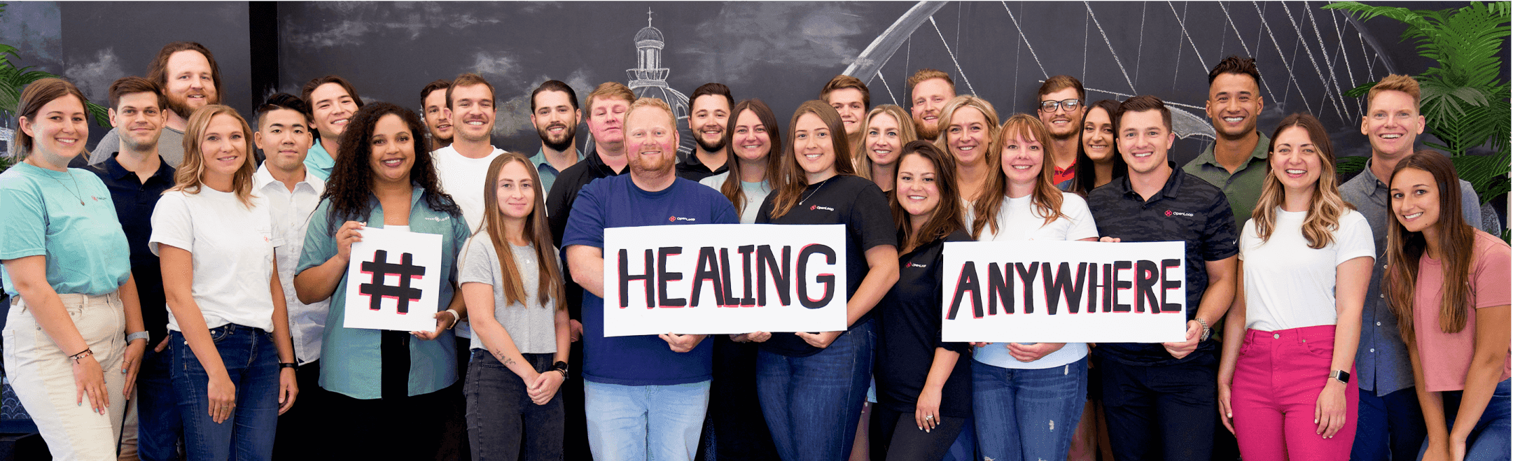 in-office OpenLoop team photo holding signs saying #HealthingAnywhere