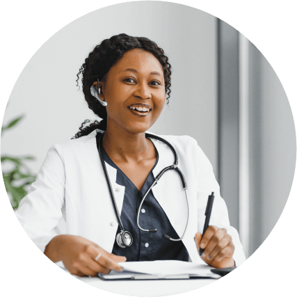 black female doctor in white coat wearing stethoscope and smiling